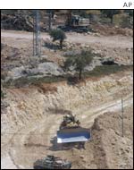 Bulldozers working on constructing the fence