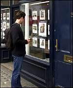 Man looks at estate agent window