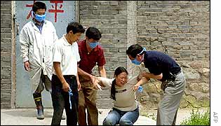 A woman breaks down outside a mortuary 3 July 2002 after discovering her husband is one of the victims who died at the Yixingzhai Gold Mine in Fanzhi County on 22 June 