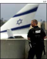 Policeman stands in front of an El Al plane