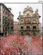 Thousands of revellers hold up traditional red scarves in the central plaza in Pamplona