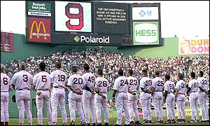Members of the Boston Red Sox pay tribute to Ted Williams beneath a large number 9, his number