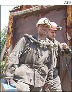 Rescuers carry their equipment after coming out of the Ukraina mine