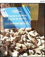 Amnesty campaigners next to a pile of stones outside Nigeria's embassy in Madrid