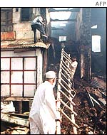 Muslim shopkeepers battle a fire in their shops in Chotta Udaipur after mobs set them ablaze in early July