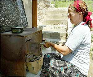 Ibrima Oric cooks a meal outside her ruined home