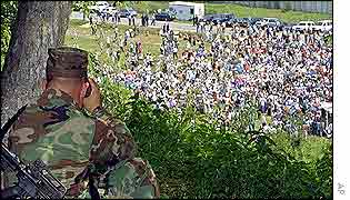 International peacekeeper looks on as mourners gather