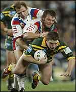 Two British players try to stop Australian hooker Danny Buderus