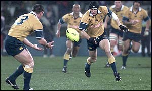 Stephen Larkham charges at the New Zealand defence
