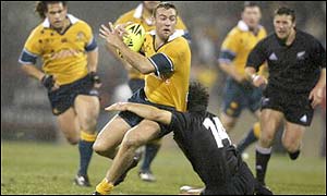 Australia's Chris Latham is tackled by Doug Howlett 