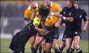 Australia's George Smith drives the ball forward in appalling conditions as he is tackled by All Black Chris Jack 