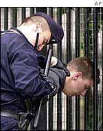 Policeman arrests Maxime Brunerie at the scene