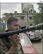 A Palestinian carries a rocket-propelled grenade while on patrol in Ayn al-Hilweh