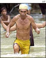 A man wades through floodwaters in north-western Bataan province