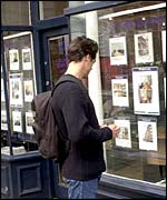 Man looking in estate agent's window