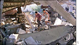Palestinian children pick through rubble of building destroyed by Israeli warplanes