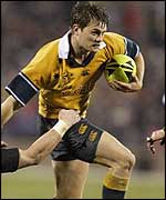 Australia wing Ben Tune fends off a tackle from New Zealand's Justin Marshall