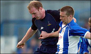 Adrian Coote, of Colchester in blue and white, challenges Spurs' Gary Doherty