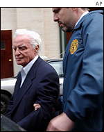 John Rigas is led from New Yorks main post office building by US postal inspector police.
