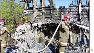 Fire crews douse charred wreckage