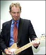 Prime Minister Tony Blair playing guitar.