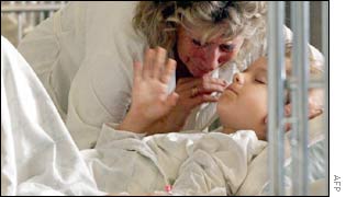 A child survivor is comforted by his grandmother