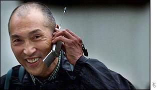 A Japanese passer by speaking on a mobile phone