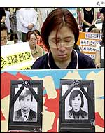 A woman prays above photos of the two dead girls