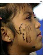 Guatemalan girl with an image of Saint Pedro stamped on her cheek