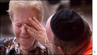 A medic comforts a crying woman near the scene of the blast