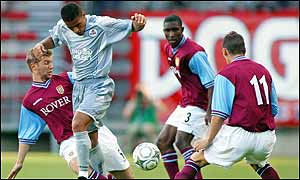 Sylvain Ndiaye (centre) is closed down by Thomas Hitzlsperger, Jlloyd Samuel and Gareth Barry 