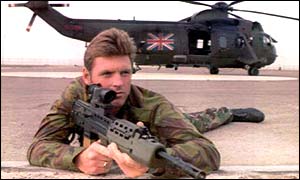 A Marine in the Gulf War protecting a helicopter with a SA80 rifle