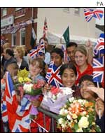 Crowds of school children greet the Queen outside the mosque