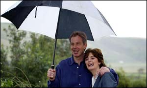 Prime Minister Tony Blair and his wife, Cherie, shelter under an umbrella at St Bees in Cumbria 