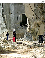 Palestinians wandering amongst rubble of Jenin 