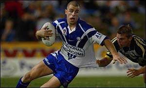 Luke Patten of the Bulldogs evades Chris Sheppard of the Cowboys