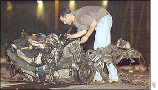 A police officer examines the wreckage