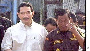 Tommy Suharto walks with a prison guard
