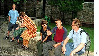 Shocked foreign students sit outside their classroom 