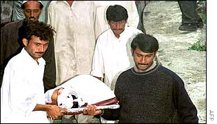 Rescue workers carry a dead body out of the morgue at Murree hospital 