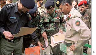 Security forces examine a bag left behind by the attackers
