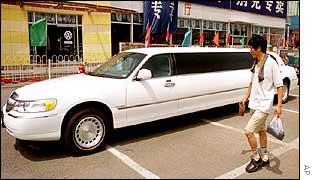 A man walks past a stretch limousine in China