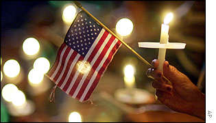 A woman holds US flag and Christian cross