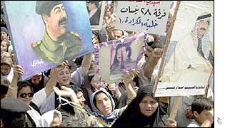 Crowd in Baghdad carry banners depicting Saddam Hussein