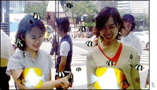 Shoppers examine a fishtank in the window of an upscale store in Ginza, Tokyo