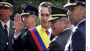 Colombian President Alvaro Uribe, with armed forces chiefs, waves to supporters 