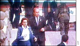 People flee from explosion as police help an injured man in the background