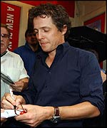 Hugh Grant signs an autograph