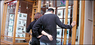 People looking in an estate agents window