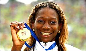Ashia Hansen poses with her gold medal after winning the triple jump